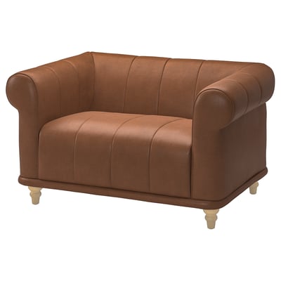 Brown leather VISKAFORS armchair, rounded shape, deep seat, wooden legs.