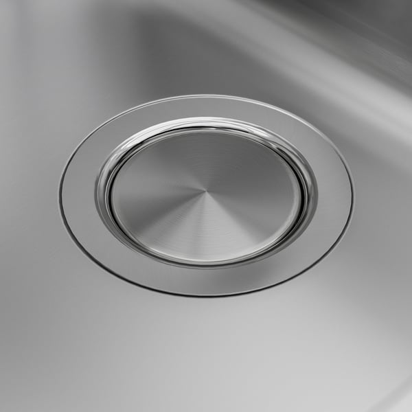 Sleek, stainless steel sink drain cover; polished, reflective surface.