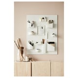 Kotitoimisto, jossa on vaaleat puuvarastot, valkoinen järjestäjä, toimistotarvikkeet ja lyijykynämaljakko.