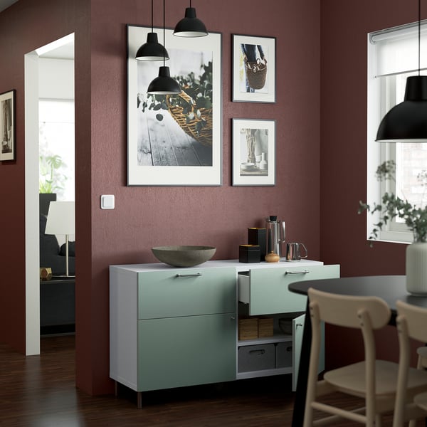 Moderni keittiö: siniset kaapit, taide, lamput, tuoli.