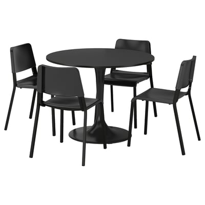 Musta DOCKSTA-ruokailuryhmä, jossa pyöreä pöytä ja 4 pinottavaa tuolia, metallijalusta, sileä kansi, modernit istuimet, joustavat selkänojat.