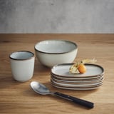 GLADELIG-setti: pieni kuppi, keskikokoinen kulho, pinotut lautaset, lusikka, hedelmät. Hiekkainen lasite, erikokoisia.