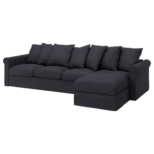 Tummanharmaa, syvä istuin, l-muotoinen sohva pehmeillä tyynyillä.