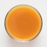Oranssinvärinen smoothie lasissa, kermainen rakenne, valmistettu hedelmistä ja vihanneksista.