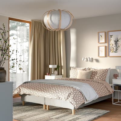 Moderni makuuhuone king bed -sängyllä, kevyt sisustus, abstraktit valot, yöpöydät.