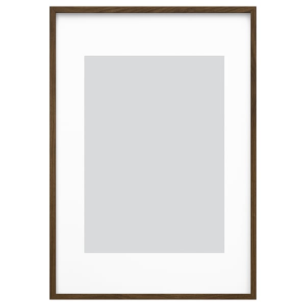 Ruskea puinen valokuvakehys valkoisella matolla, valmiina ripustettavaksi ja näyttämään kuvia.