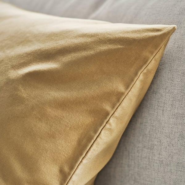 Kullanvärinen samettityynynpäällinen, jossa on sileä, ylellinen rakenne ja hienovarainen kiilto.