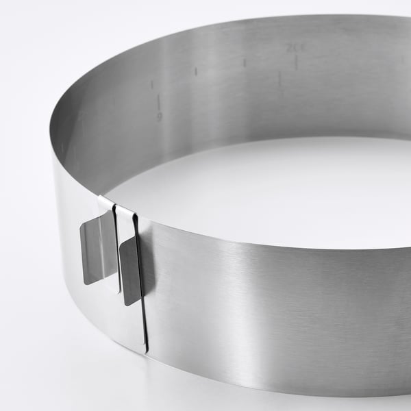 Hopeanvärinen ruostumattomasta teräksestä valmistettu pyöreä kakun leivontakehys, säädettävät, korkeat reunat helpottavat käyttöä.