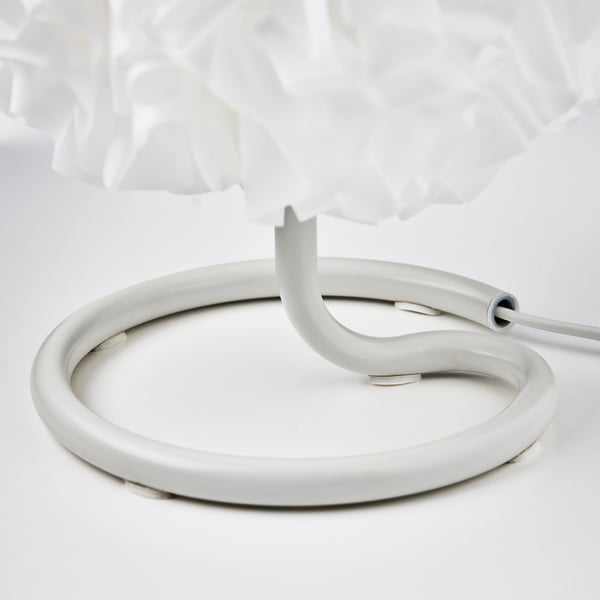 Moderni valkoinen pöytävalaisin, jossa on pehmeä, pörröinen varjostin ja tukeva jalusta.