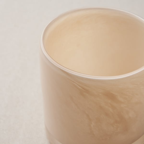 Sylinterimäinen kynttilänjalka, jossa on sileä, kiiltävä pinta ja hienovaraiset, tyylikkäät kuviot.