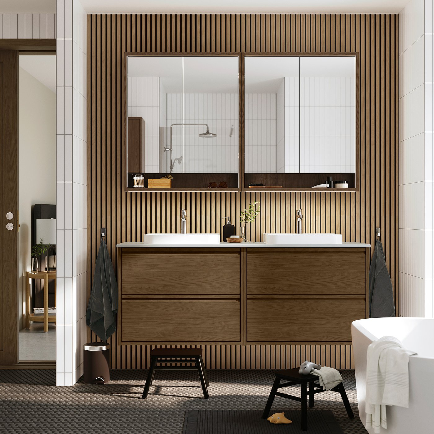 Modernt badrum: brunt skåp, 2 handfat, speglar, svart pall, handdukar. Minimalistisk design.