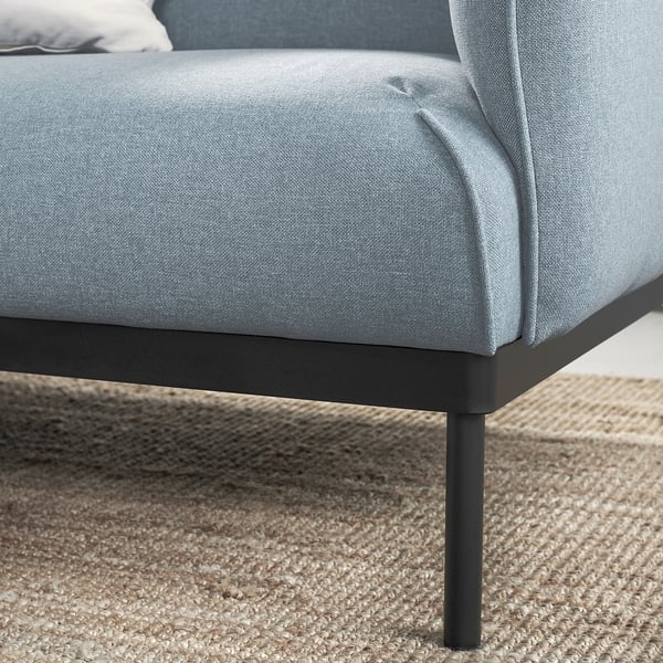 Modern ljusblå soffa, eleganta metallben, mjuka kuddar.