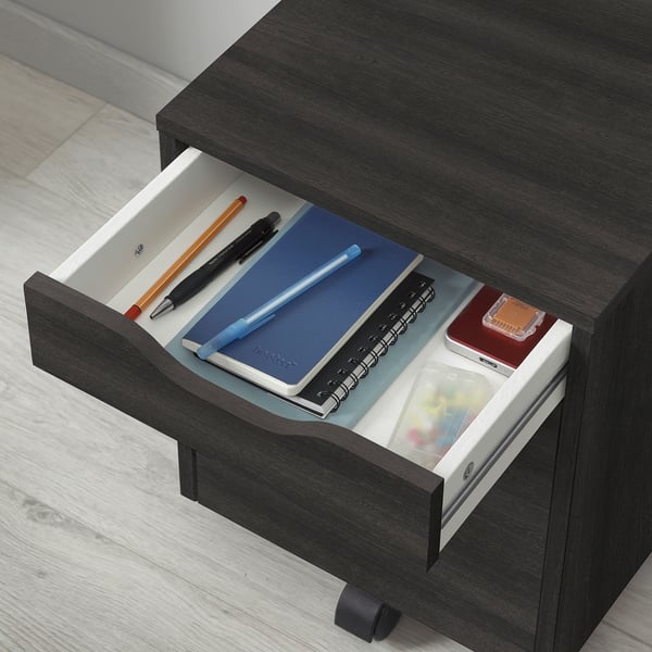 Öppen låda som avslöjar pennor, anteckningsböcker och hållare. Perfekt för förvaring av kontorsmaterial.