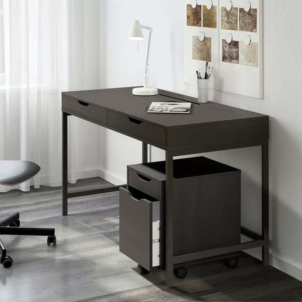 Mörkgrått ALEX skrivbord med lådor, lampa och tillbehör i hörnet.