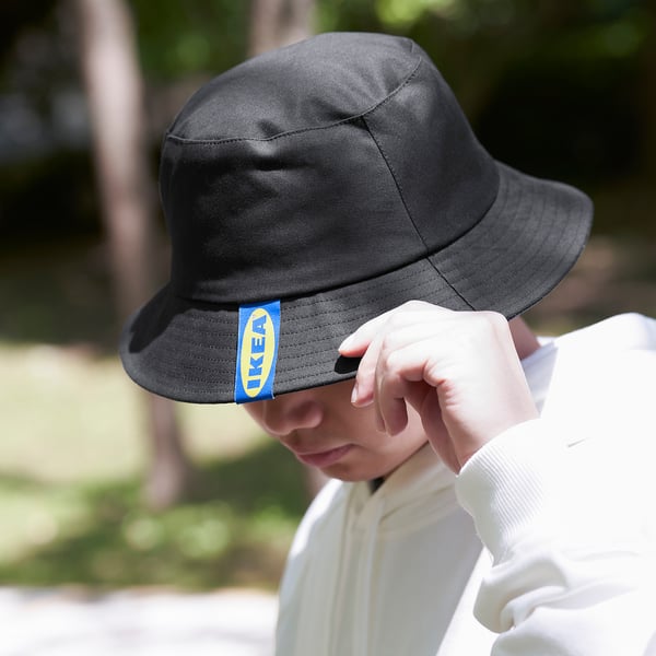 En person som bär en AURTIENDE-hatt, som skyddar mot solen, perfekt för utomhusaktiviteter.