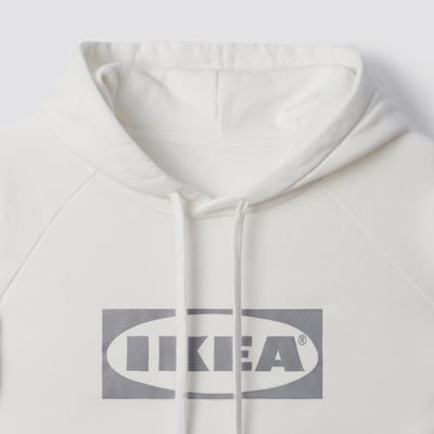 Vit huvtröja med tryck med IKEA-logotyp framtill. Mjuk bomull, kvalitetsdesign.