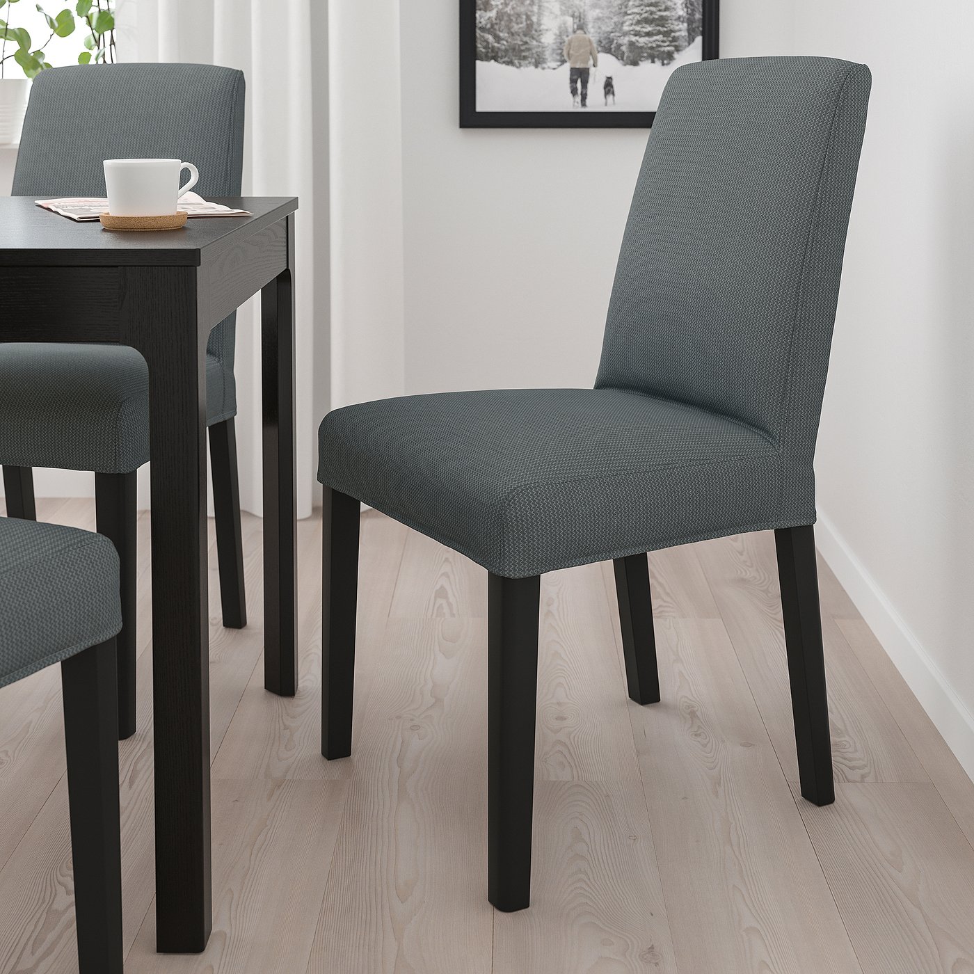 Modern matservering: grå BERGMUND stolar med träben. Bekväma, täckta säten, matchande mörkt bord. Perfekt för mysiga måltider.