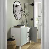 Modern skänk med öppna dörrar, förvaring, spegel, lampa och korg.