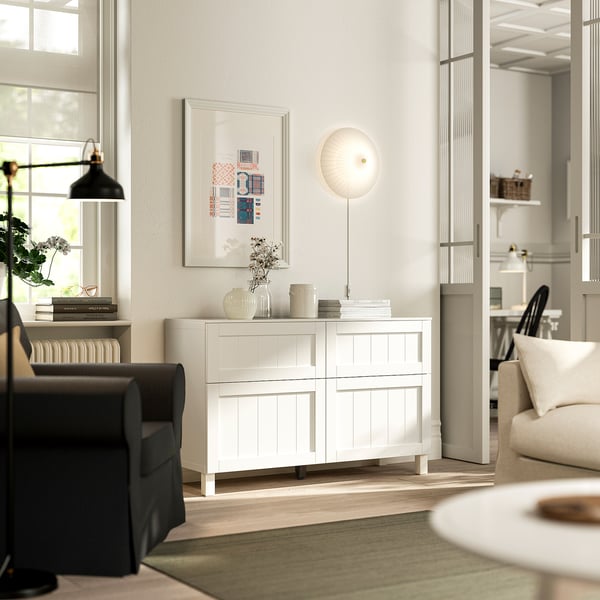 Modern vardagsrum med BESTÅ-skänk , stol, soffa och inredning.