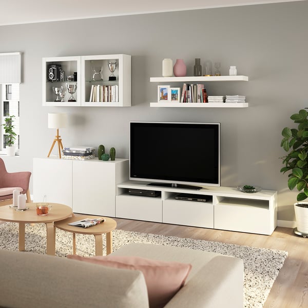 Modernt vardagsrum med BESTÅ tv-bänk, hyllor, beige soffa, soffbord, minimalistiskt.