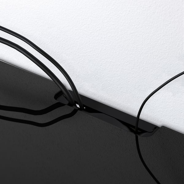 Topppanel i svart glas för förvaring, med kabelutgång för organiserad hantering.