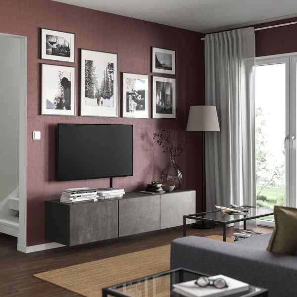 Modernt rödbrunt vardagsrum med tv-bänk, foton och golvlampa.