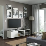 Modernt vardagsrum med tv-bänken BESTÅ, flyttbara hyllor och väggkonst.