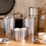 BETTHAJ burkar: silverstål, runda med böljande design, staplade; rymmer små föremål, passar bra med kaffebryggare.