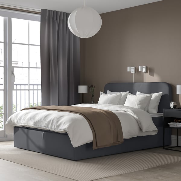 Minimalistiskt sovrum: sängen BLÅFJÄLLET, stort fönster, mjuk sänggavel, hängande lampa.