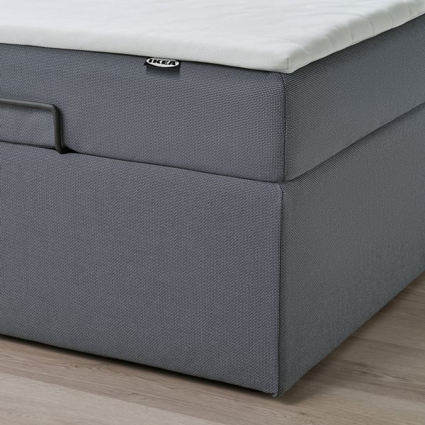 Närbild av en lyftmekanism i ottomanska sängar, som visar förvaring under sängen och ikea-etikett.