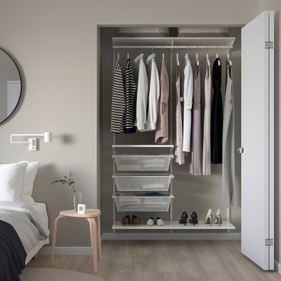 Öppen garderob med ordning på kläder och skor. Modern design, vita och grå färger. Nätlådor och hängstänger. Skohylla i botten.