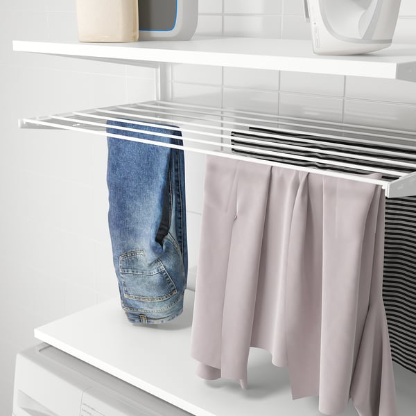 BOAXEL väggförvaring: torkställning rymmer jeans, rosa byxor och randig skjorta. Enkel tvättorganisation.