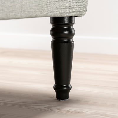 Svart trästolsben med svängd design på ett lätt trägolv.