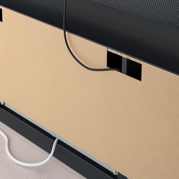 En modern tv-bänk med kabelhanteringshål, breda lådor för förvaring och en elegant design.