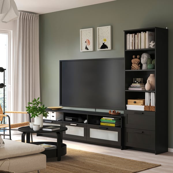 Mysigt vardagsrum med BRIMNES tv-bänk och bokhylla. Mörkgrå, modern, rymmer tv och böcker snyggt. Kurerad inredning; soffa, soffbord, matta; grön vägg.