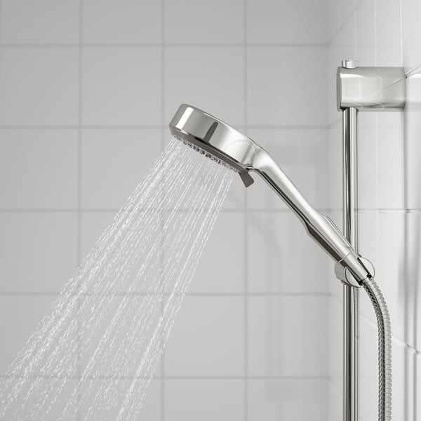 Handdusch i krom med flera sprayalternativ. Fylliga, dimma och massageinställningar synliga. Vattnet rinner i en bred, jämn bäck.