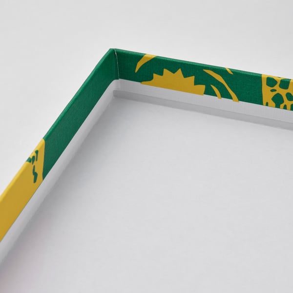 Ram med livfulla gröna och gula bladmönster, hörnen skarpt vikta, vilket visar på hantverk av hög kvalitet.