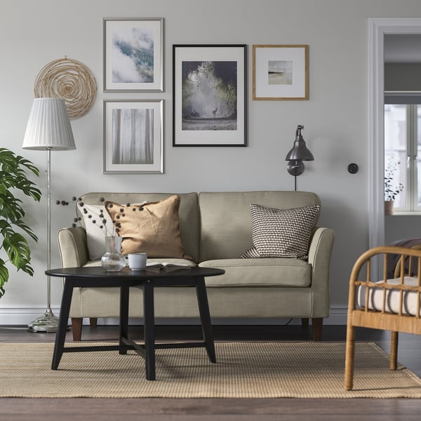 Grå EKHOLMA soffa med prydnadskudde i mysigt vardagsrum.