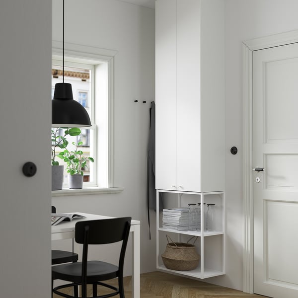 Modern kontorshörna med ENHET vitt skåp och skrivbord. Svart stol, hängande lampa och grå gardiner. Plantera på fönsterbrädan. Snygg och minimalistisk design.