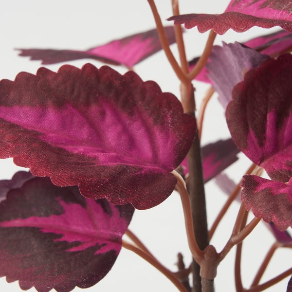 Konstgjord växt med livfulla rosa blad, som visar realistisk textur och naturliga kurvor.