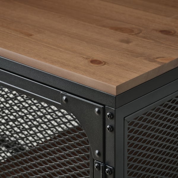 Närbild på FJÄLLBO skrivbords robusta, rustika träskiva och industriella metallgallerbas.