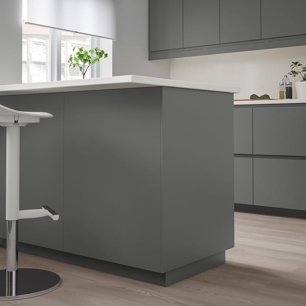 Modern grå FÖRBÄTTRA köksö med elegant bänkskiva, högskåp och barstolar.