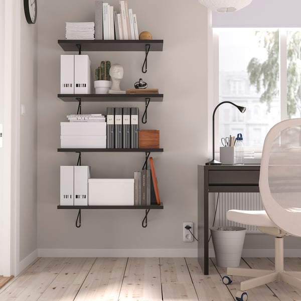 Minimalistiskt hemmakontor med vita stolar, FÖRLÄGGARE-hyllor, böcker, kaktus och lampa.