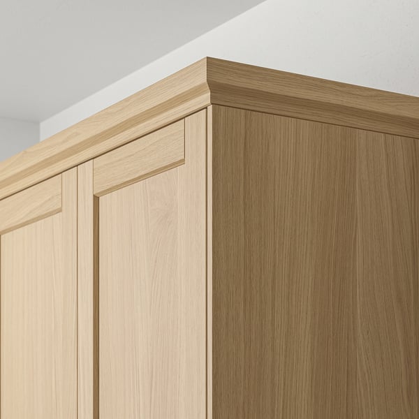 Köksskåpslister i trä, med varm naturlig ekfinish, designade för att dölja belysning och förbättra skåpets estetik.