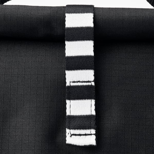 Svartrandig väska med robusta handtag som visas nära och visar upp dess kvalitetsstruktur och design.