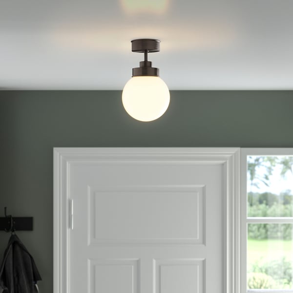 Taklampa i frostat glas ovanför vit dörr för hallar eller badrum.