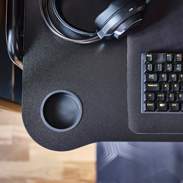Modern gamingbord med inbyggda mugghållare och tangentbordsutrymme. Robust stålkonstruktion, lämplig för tung utrustning.