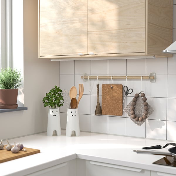 Köksbänk med två roliga FRÖVÄXT vaser, växter och redskap.