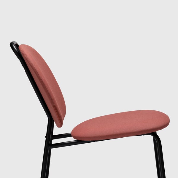 Modern röd stoppad stol med svart metallram, designad för komfort och enkel rörelse.