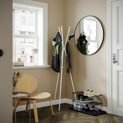 Modern entré med trägolv, skohyllan GREJIG, klädhängare, spegel, stol och växt.